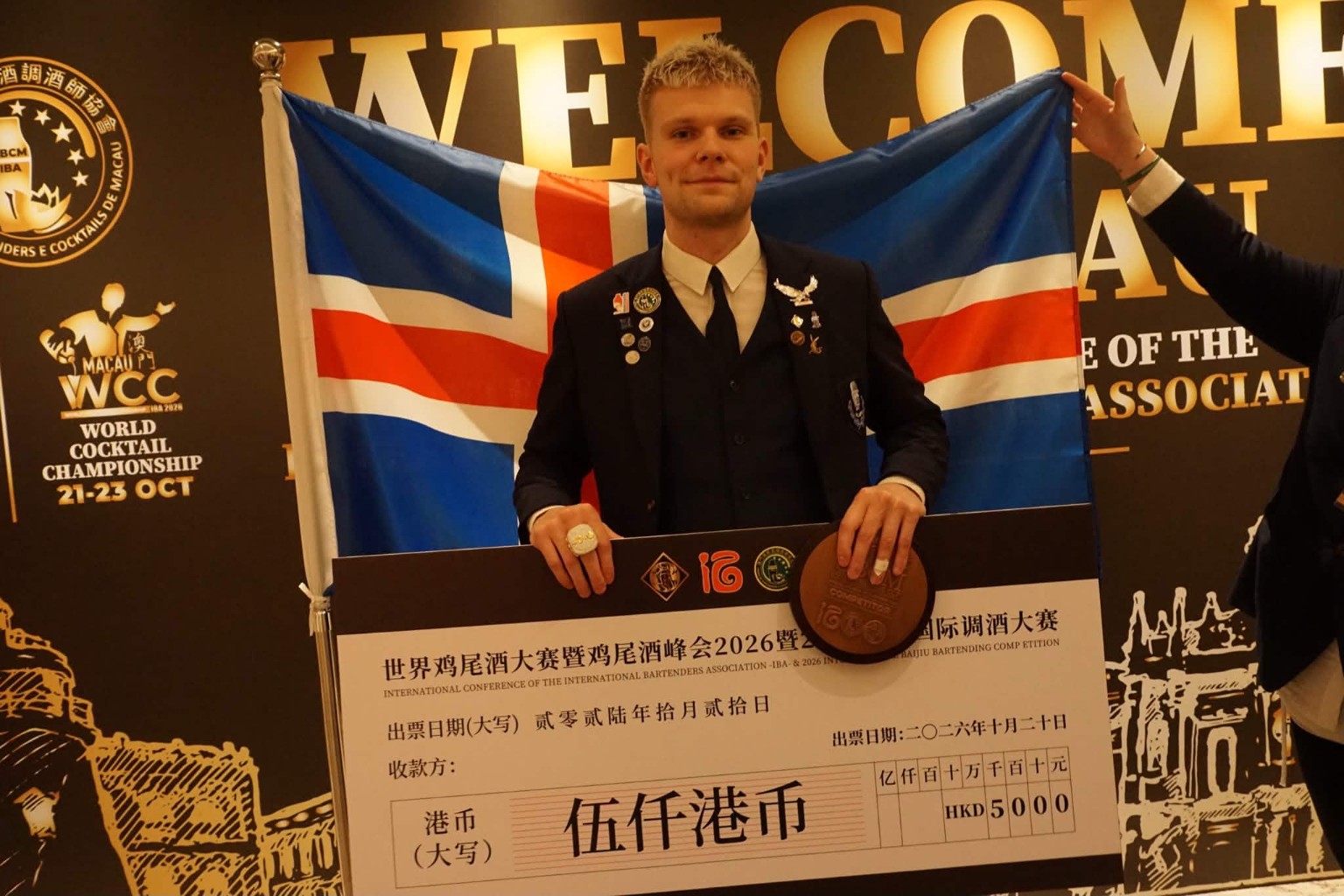 Pétur Kolka með sigurlaunin fyrir framan íslenska fánann í Macau.
